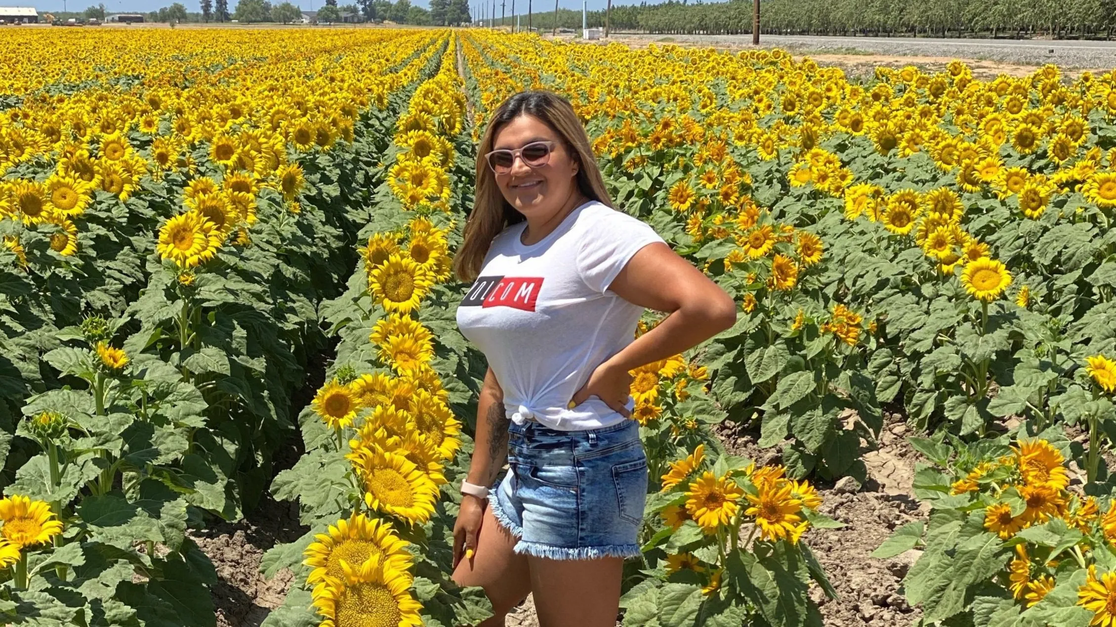 Maria Lupercio standing in a field of sunflowers